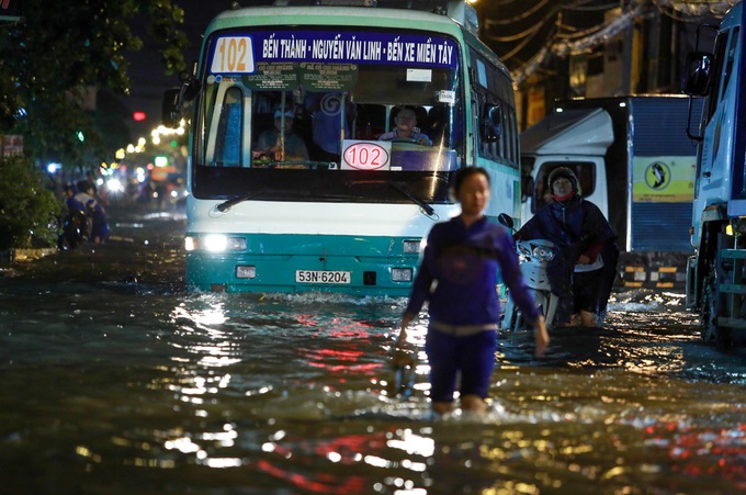 Mưa lớn, 'phố biến thành sông', người dân Sài Gòn bì bõm dắt xe 'bơi' về nhà - Ảnh 4